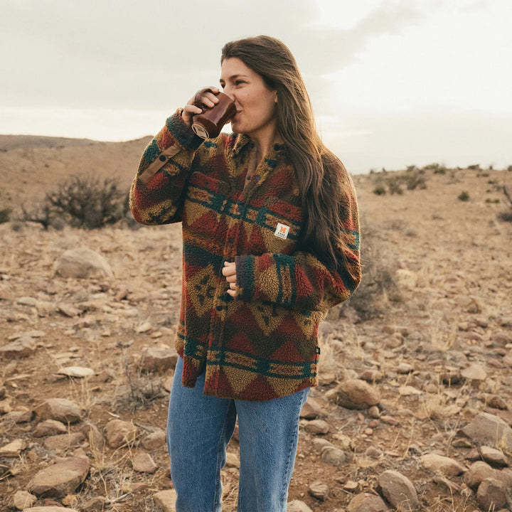 Woman wearing a patterned jacket in a desert landscape
