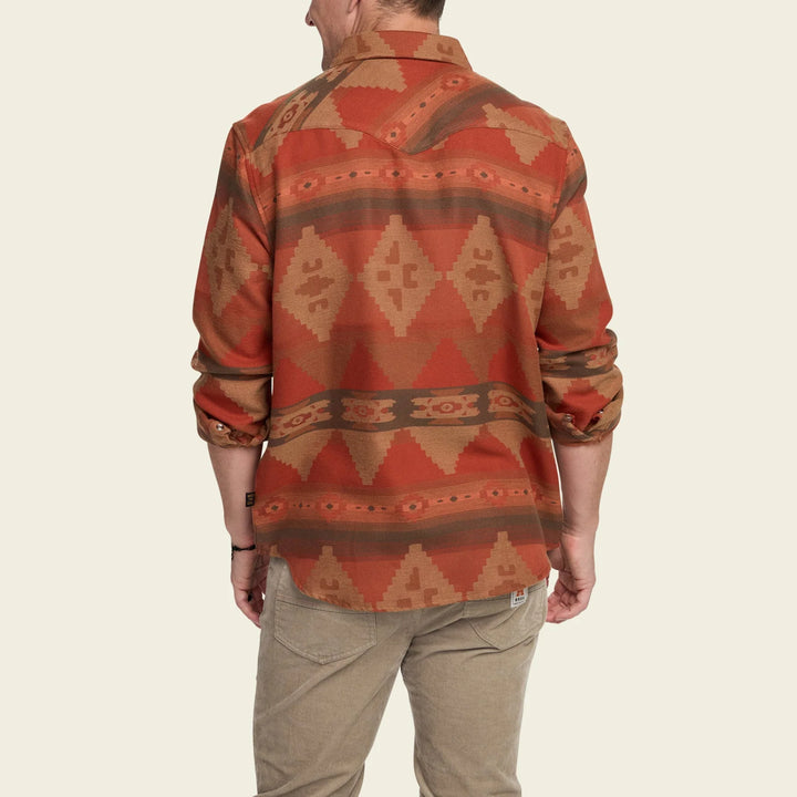 Person wearing a patterned shirt with a neutral background