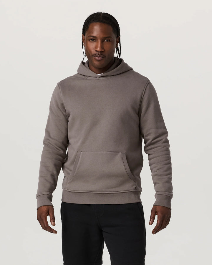 Man wearing a gray hoodie on a plain background