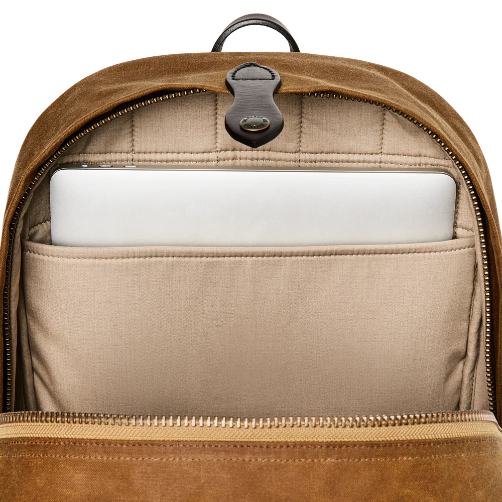 Open brown suede backpack showing the interior with a beige fabric laptop compartment holding a white laptop, on a white background.