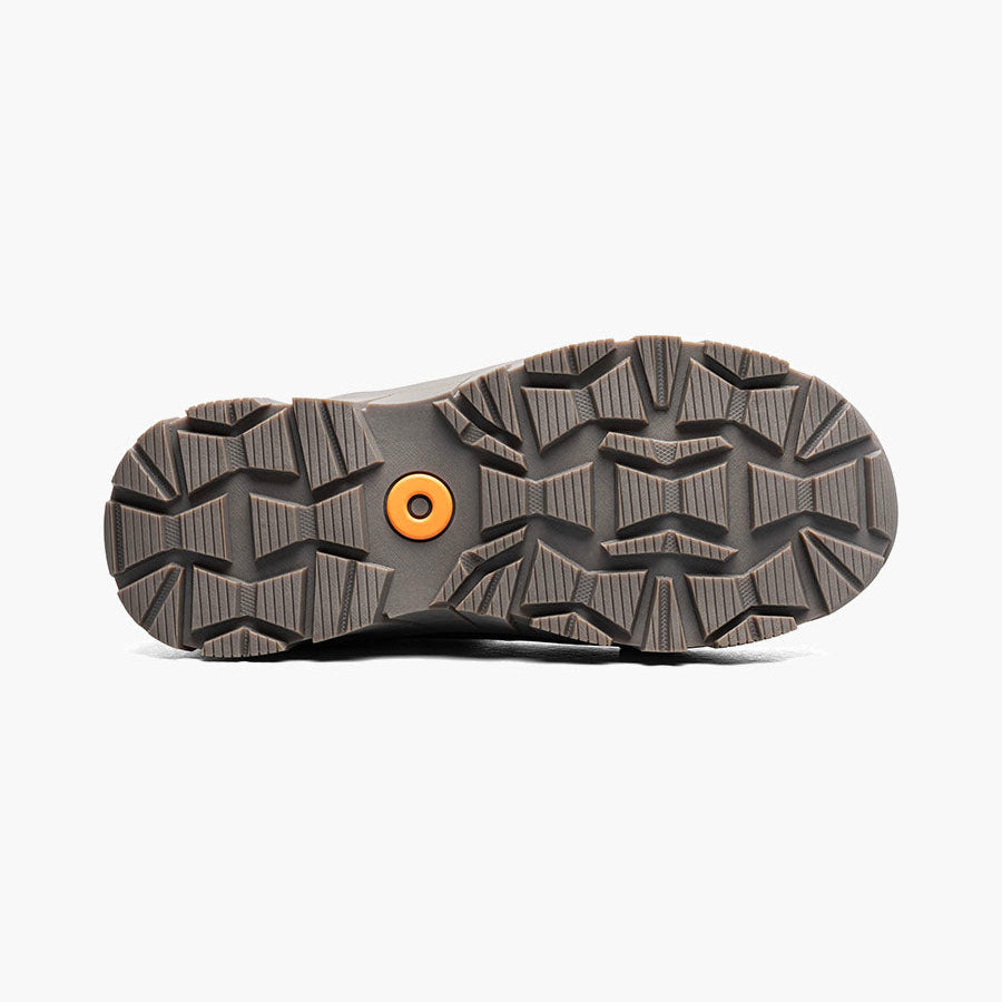 The treaded outsole of a dark gray hiking boot, showing a textured pattern and a small orange circular accent near the center, photographed from a top-down view on a light gray background.