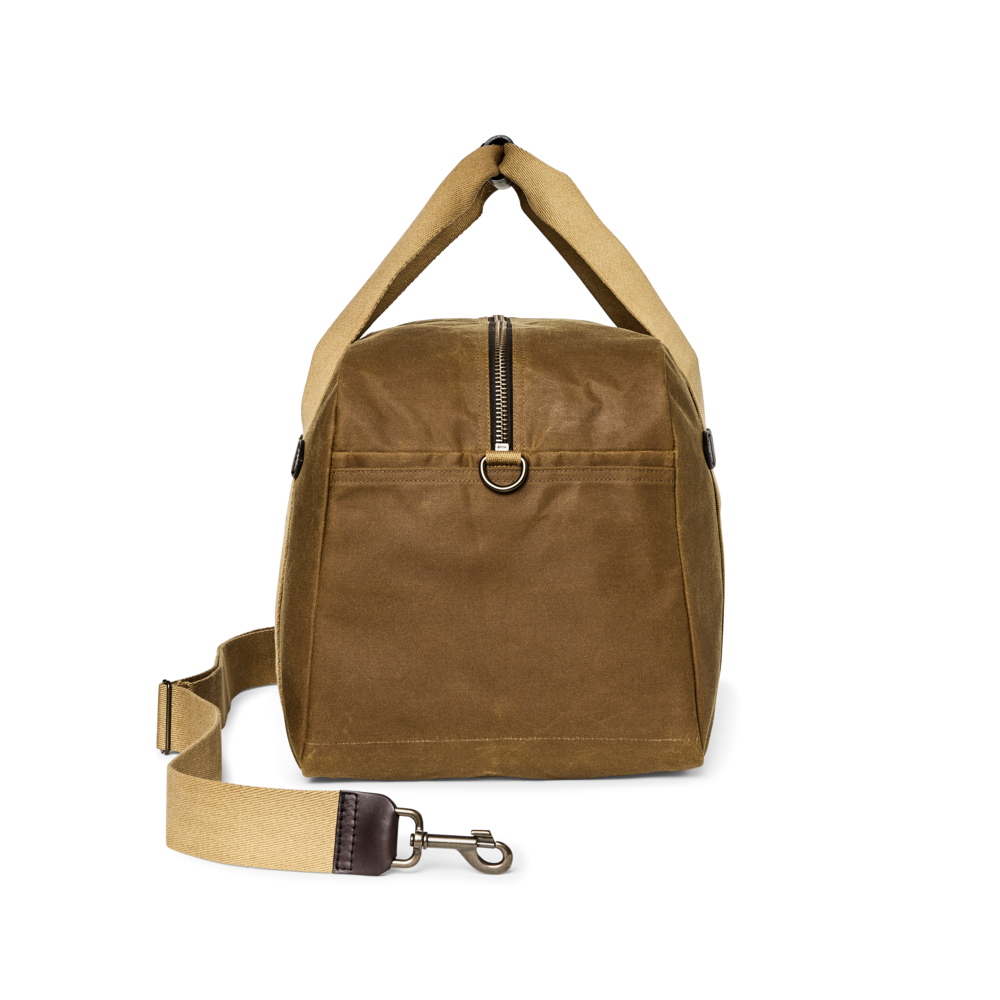 A brown waxed canvas duffel bag with a tan shoulder strap and a matching detachable strap, shown on a plain white background.