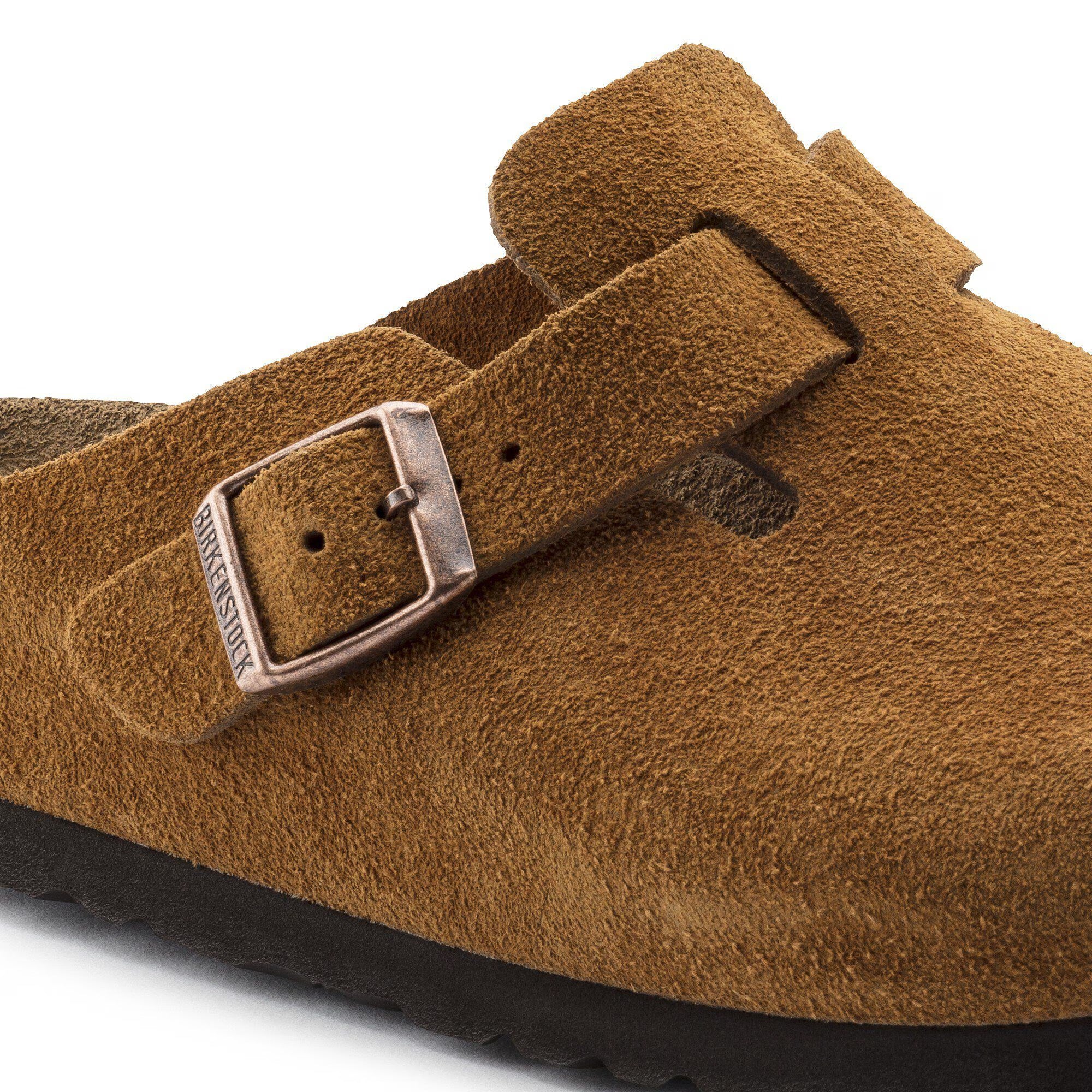 Brown suede clog with a buckle on a white background