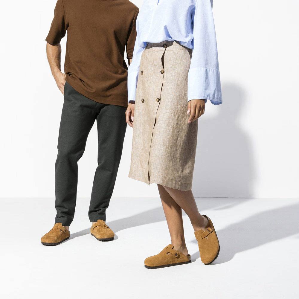 Two people standing side by side wearing brown shoes on a white background