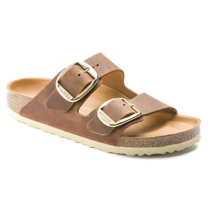 Brown sandal with gold buckle on a white background