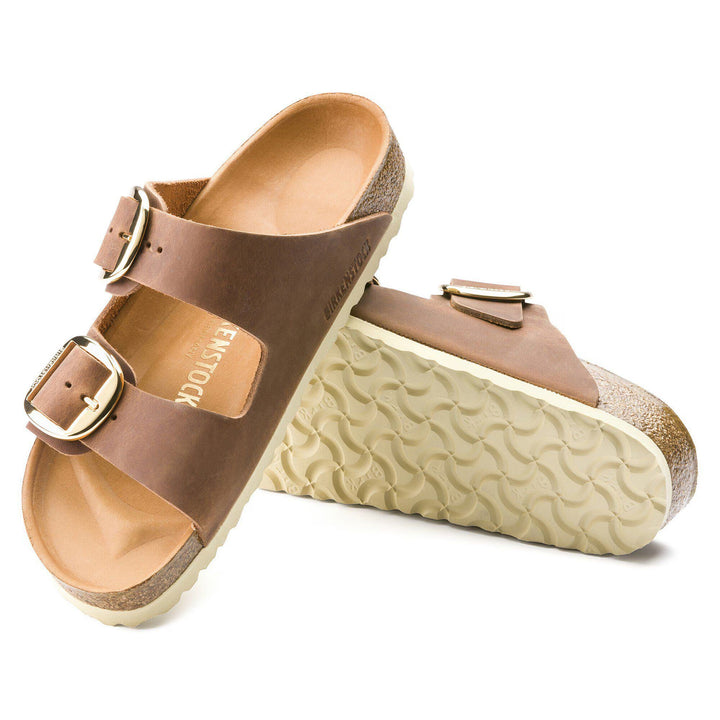 Brown sandals with gold buckles on a white background