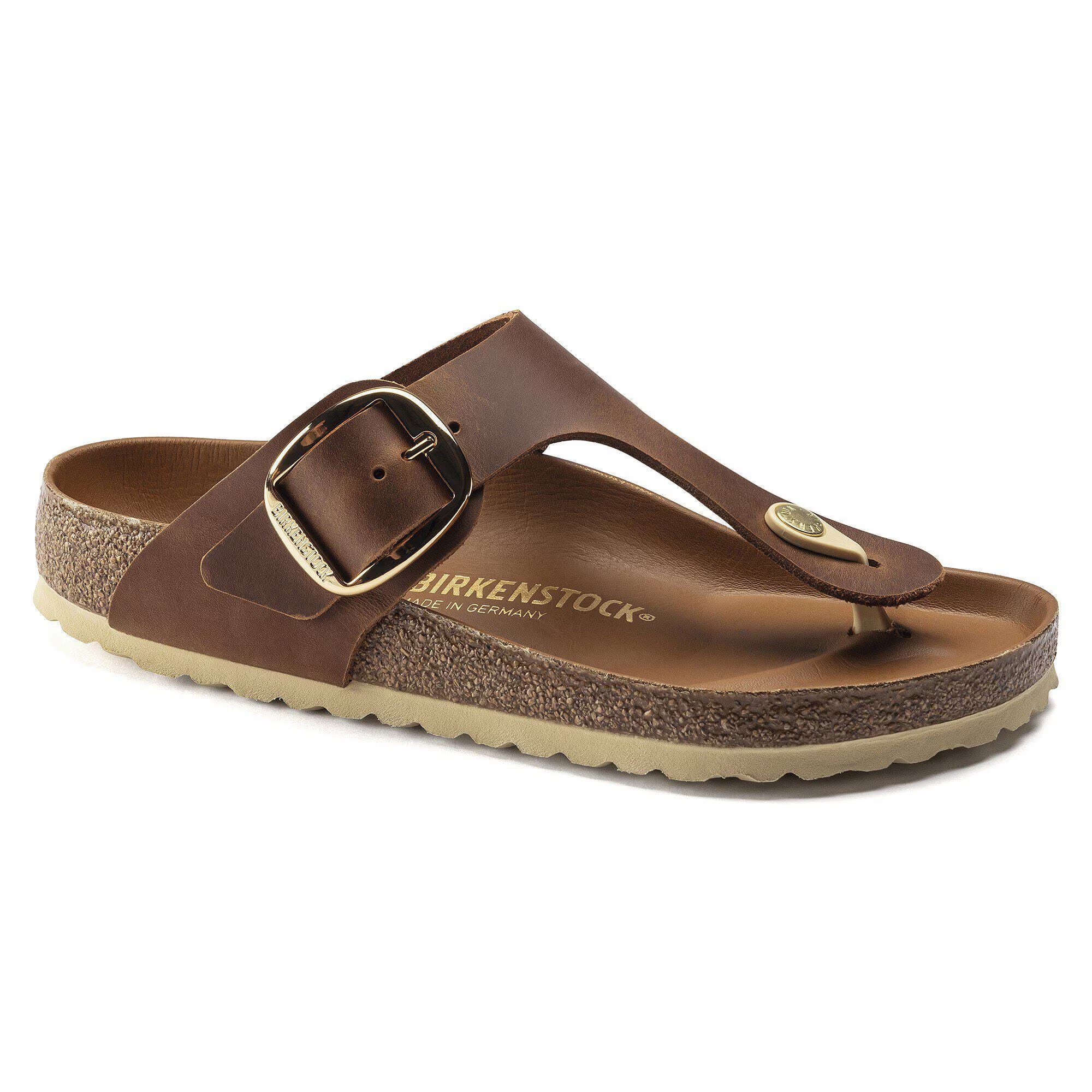 Brown sandal with a gold buckle on a white background