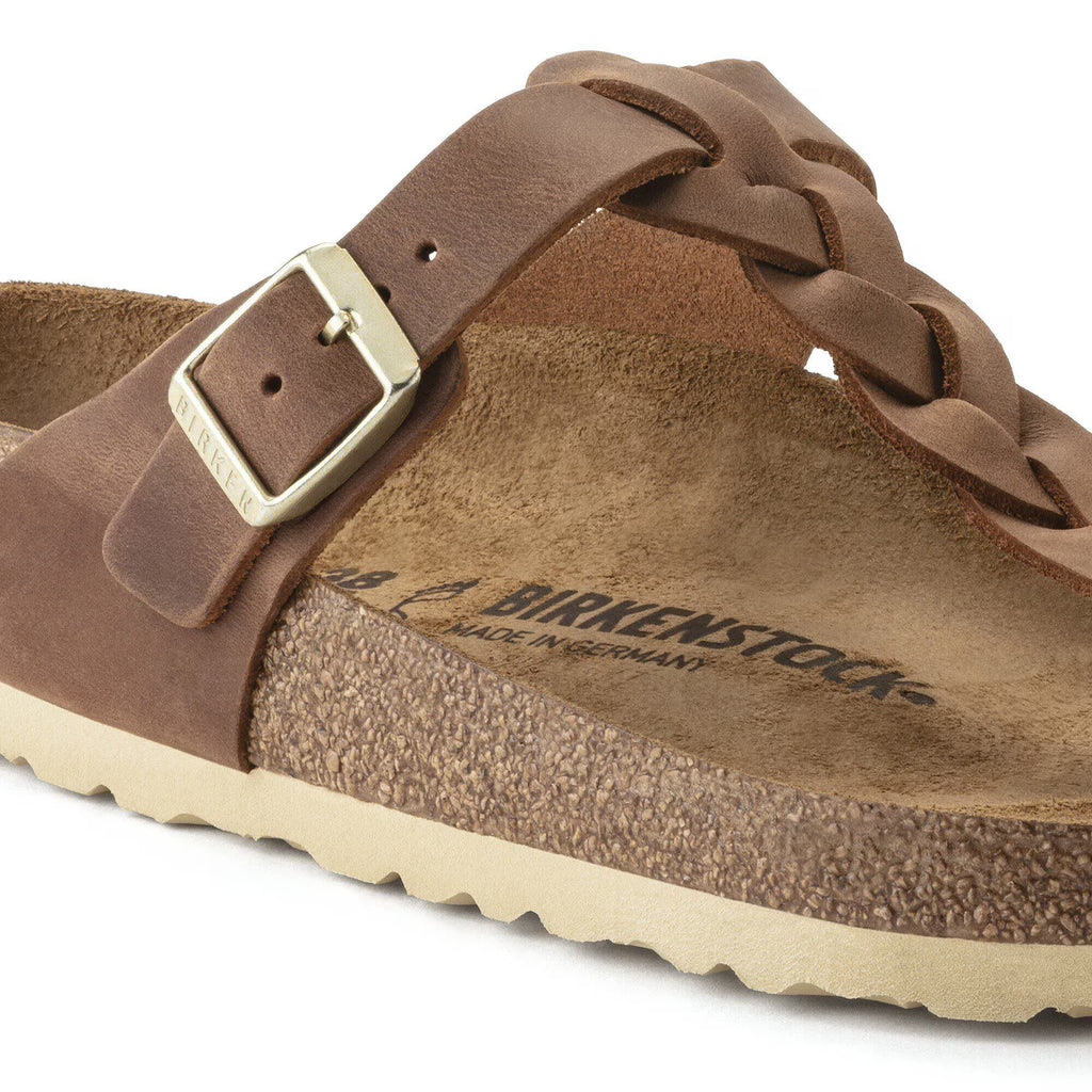 Brown leather sandal with braided strap and visible Birkenstock logo on a white background