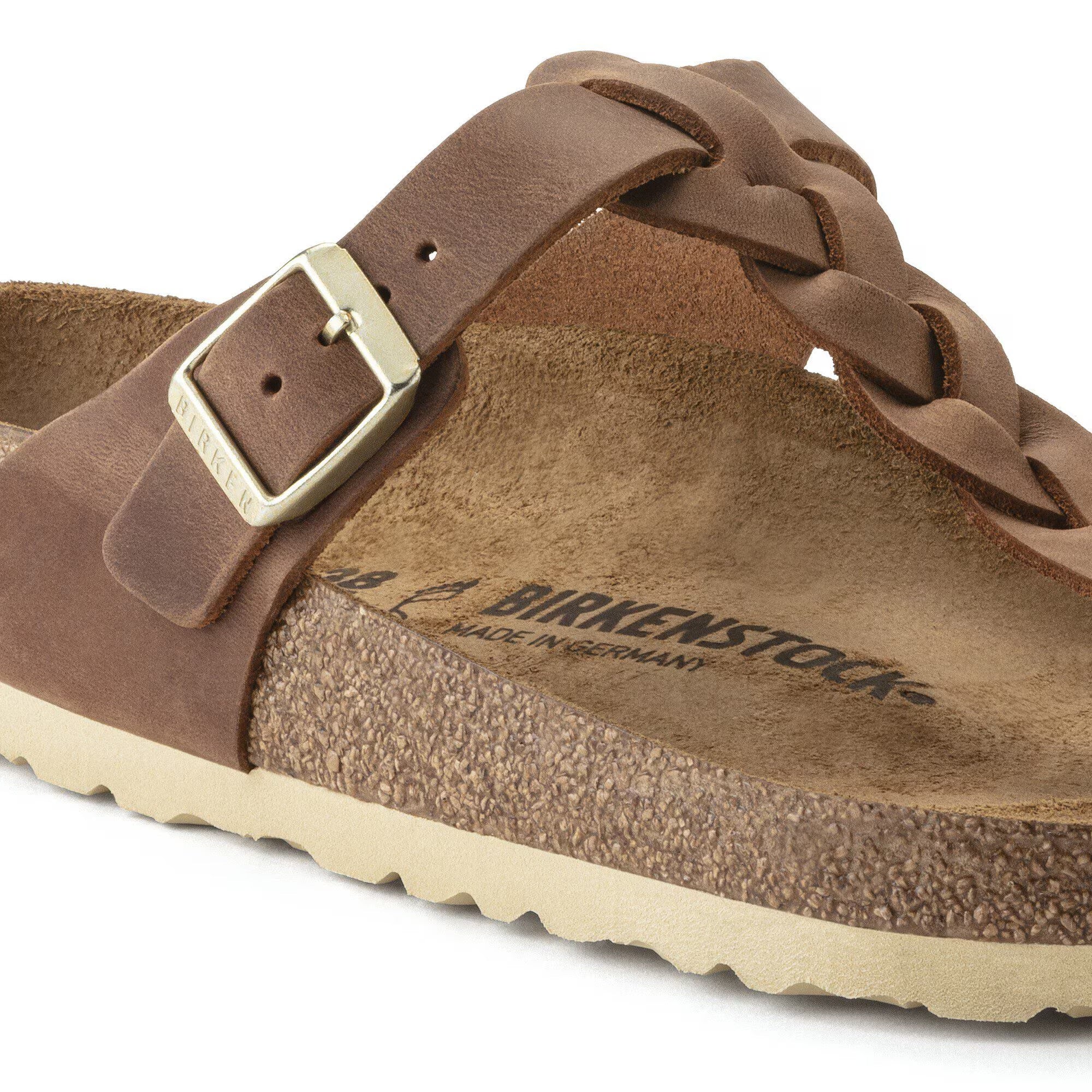 Brown leather sandal with braided strap and visible Birkenstock logo on a white background