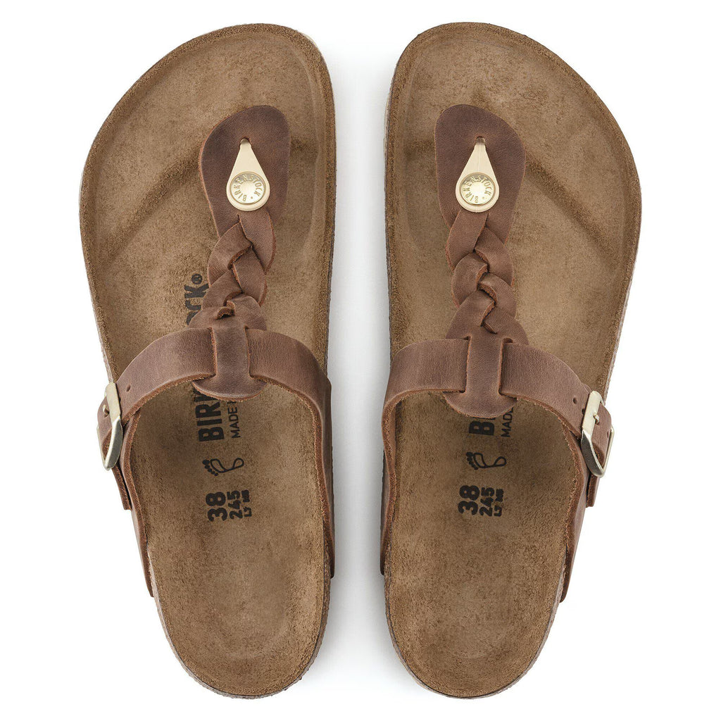 Pair of brown sandals with braided straps on a white background