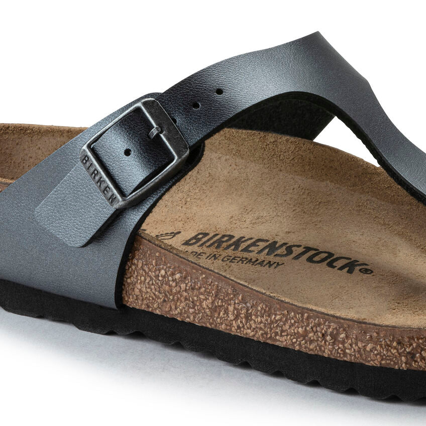 Birkenstock sandal with black strap and brown footbed on a white background