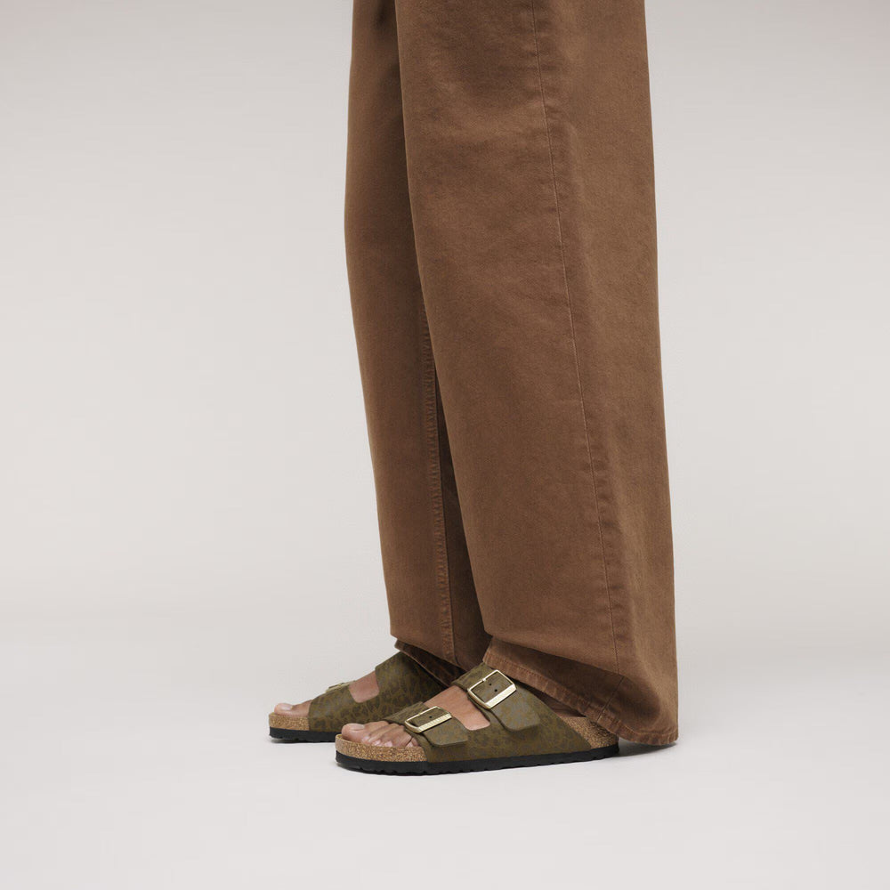 Brown pants worn by a person on a white background