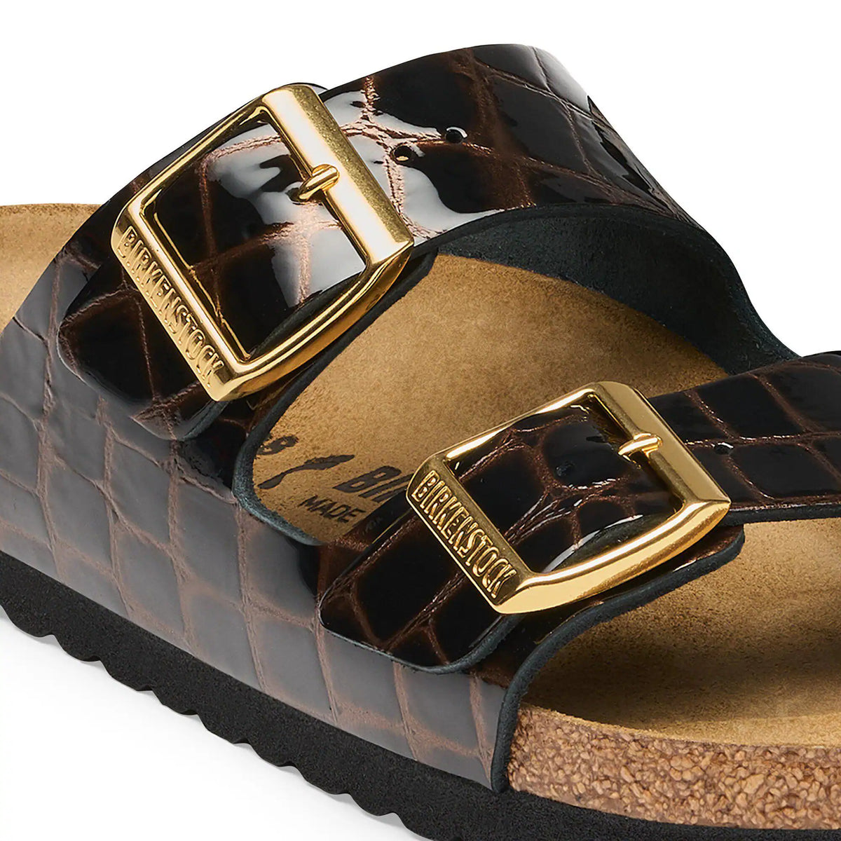 Brown sandal with gold buckle on a white background