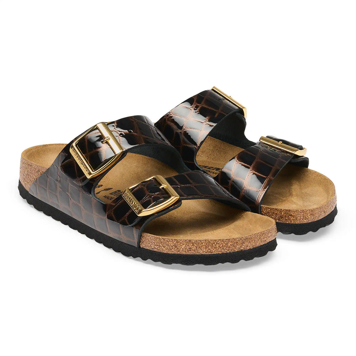 Pair of brown sandals with gold buckles on a white background