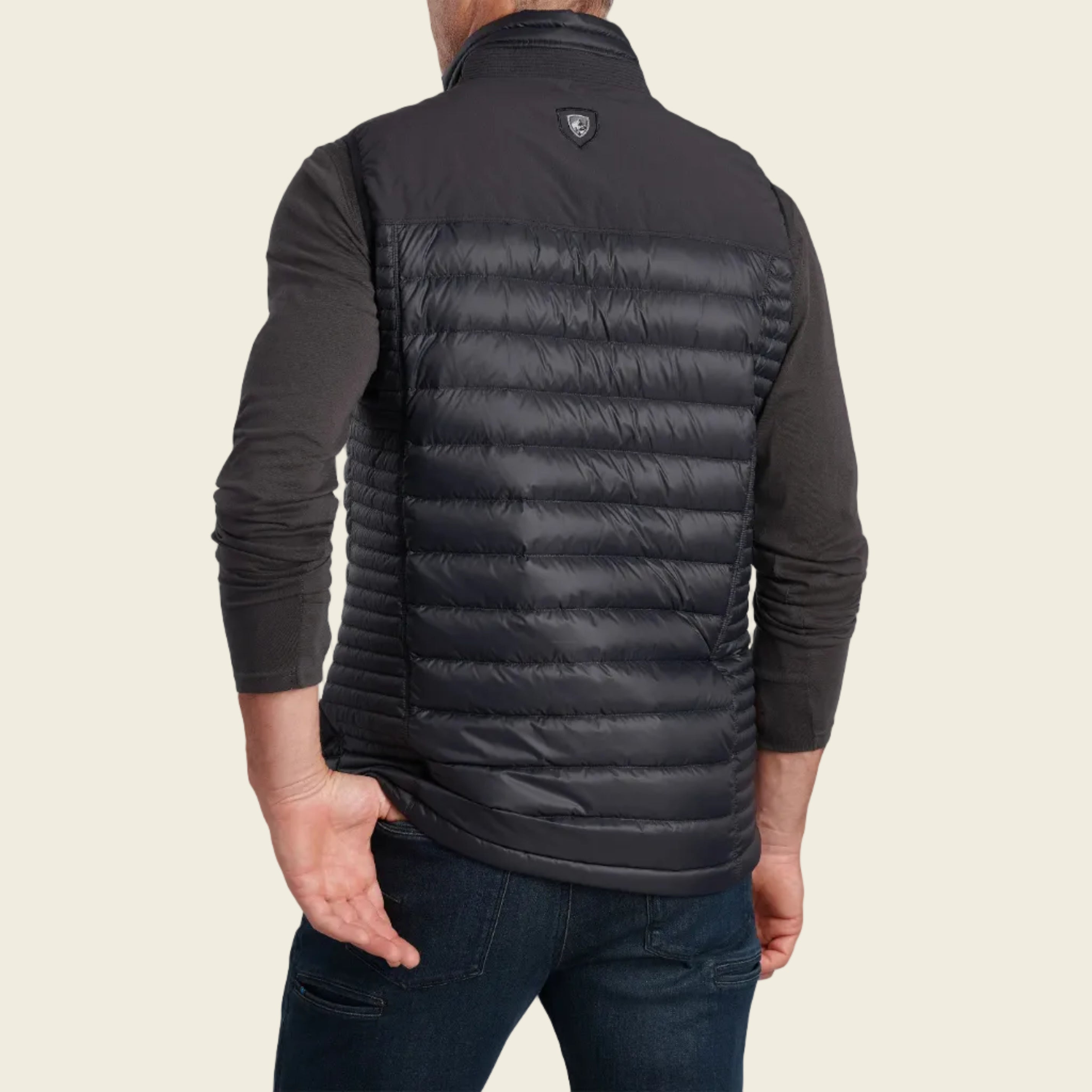 Person wearing a black puffer vest on a white background