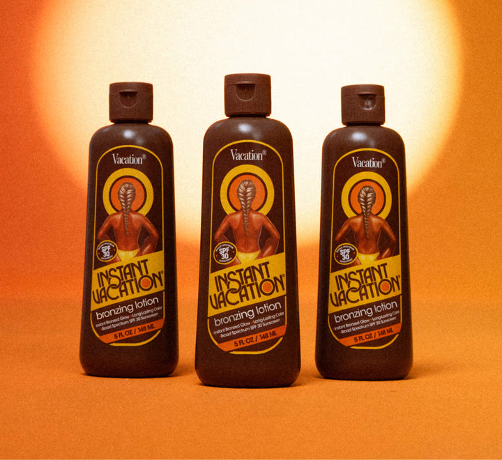 Three bottles of 'Instant Vacation' bronzing lotion on an orange background