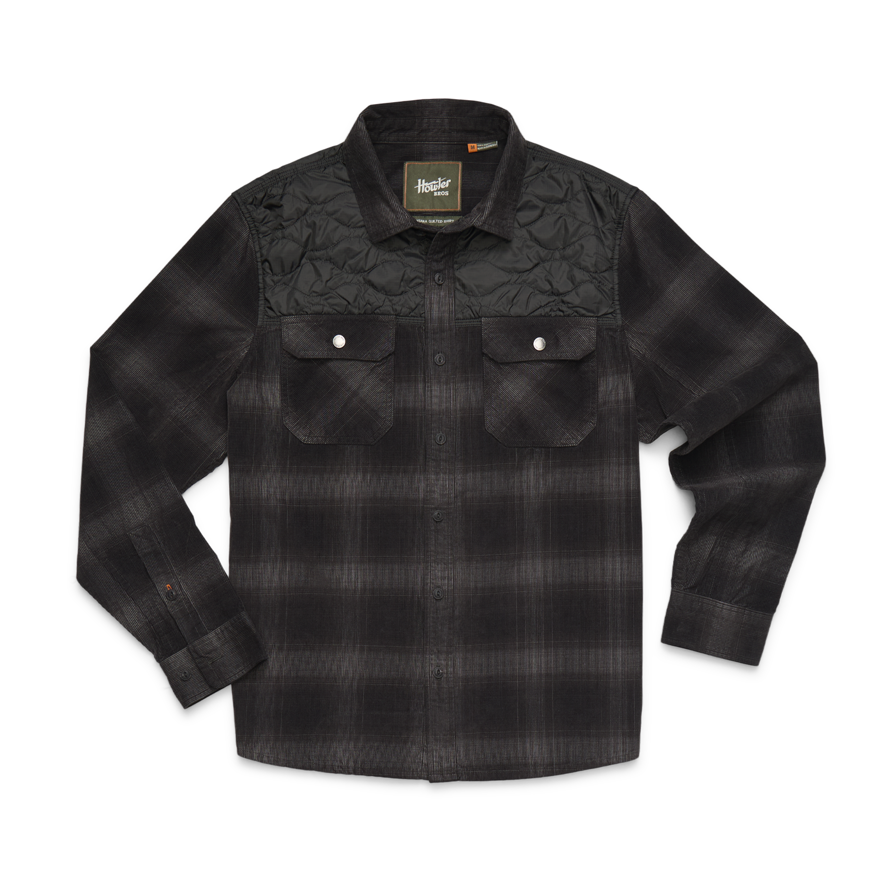 A black and dark gray plaid long-sleeve button-up shirt with a quilted yoke on the chest, featuring two buttoned flap pockets on a white background.