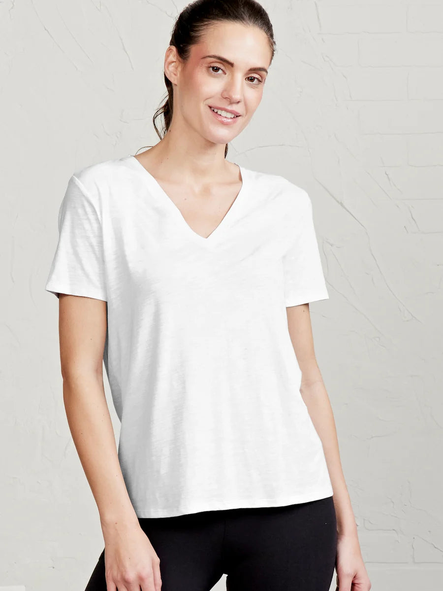 Woman wearing a plain white t-shirt against a light gray background