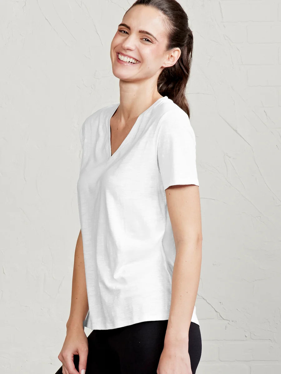 Woman wearing a white t-shirt against a plain background