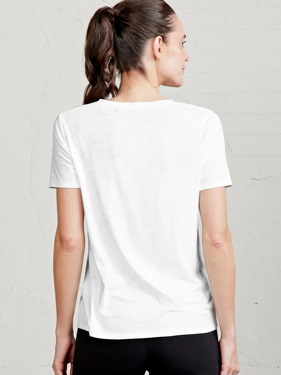 Woman wearing a plain white t-shirt against a light gray background