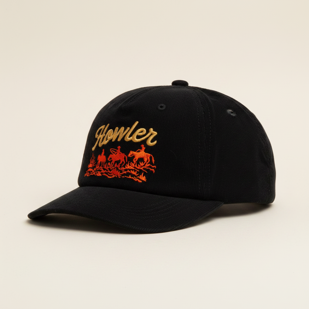 A black corduroy baseball cap featuring embroidered gold 'Howler' script and an orange cowboy scene on the front, set against a plain white background.