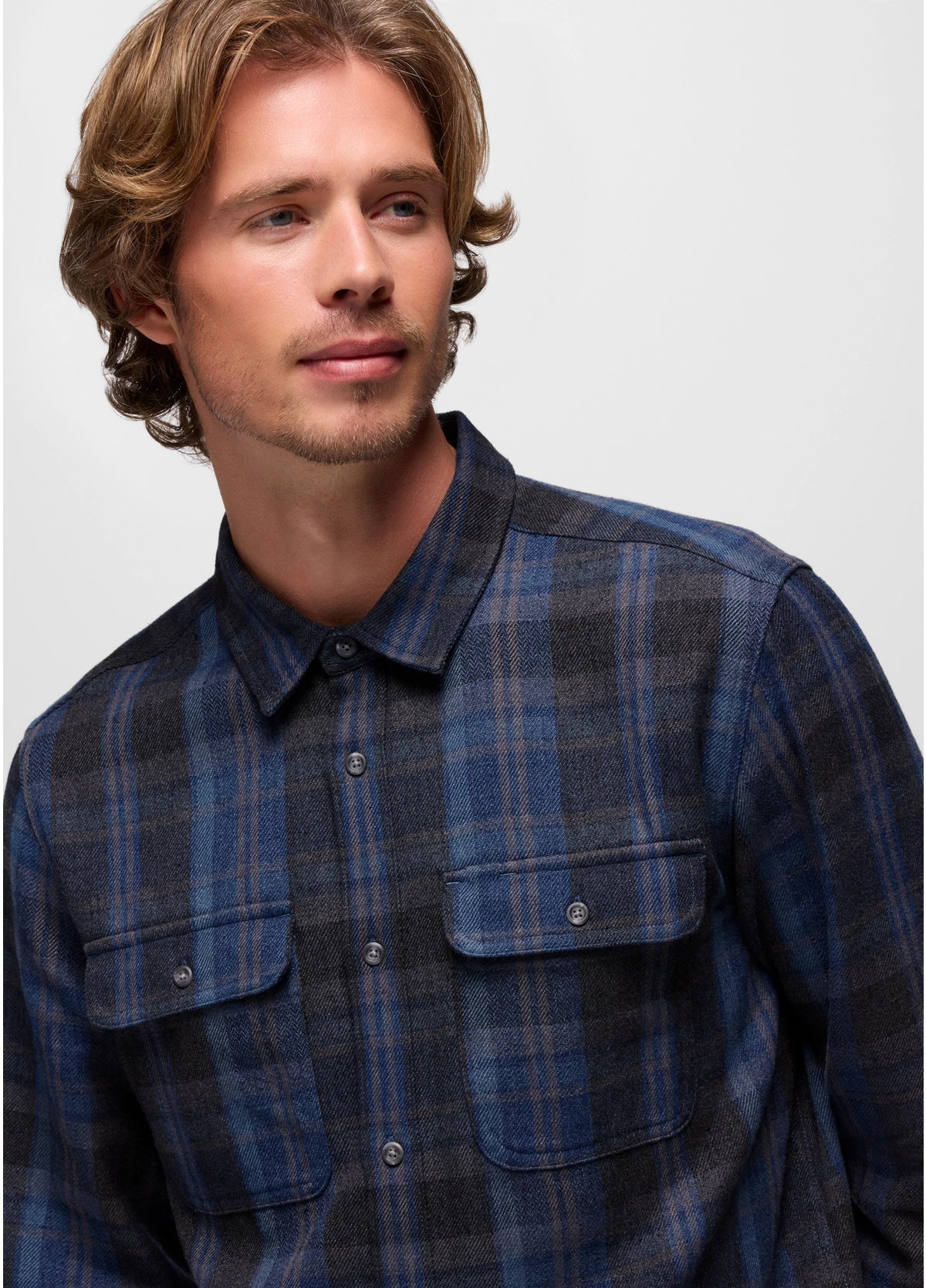Man wearing a blue plaid shirt against a plain background