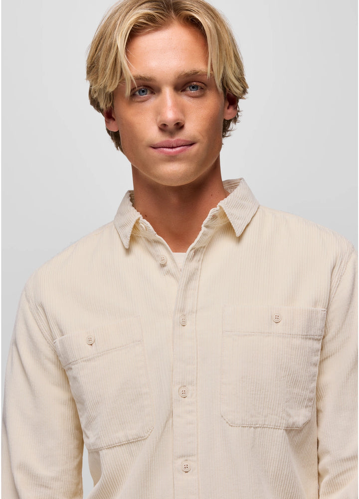 Man wearing a beige shirt against a plain background