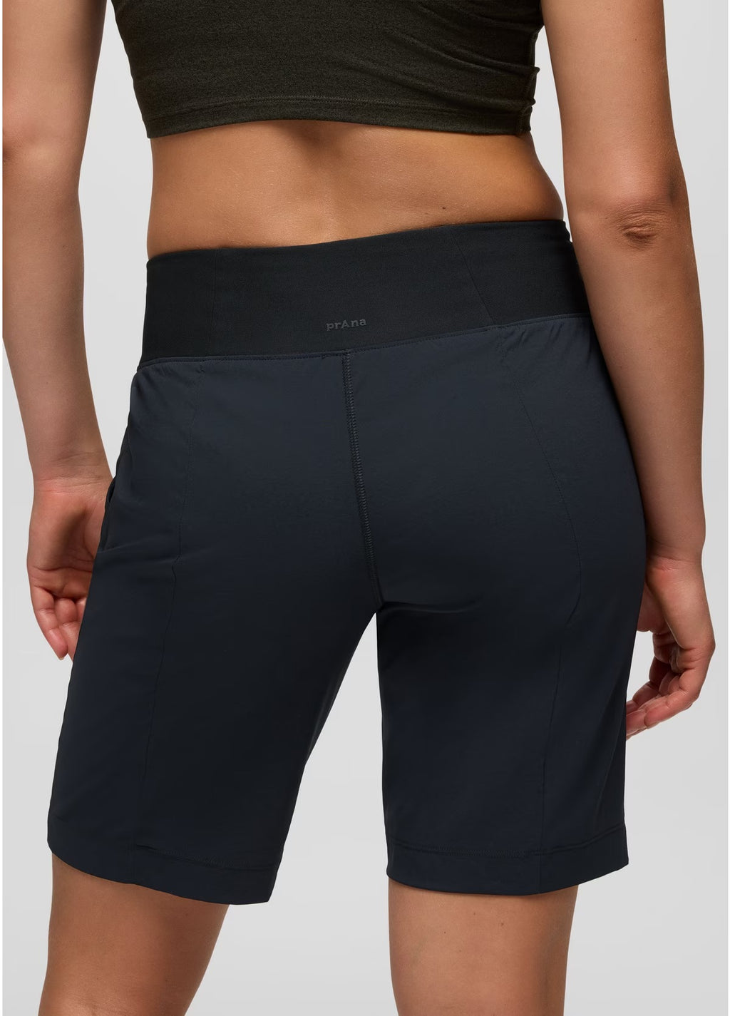 Person wearing black athletic shorts on a plain background