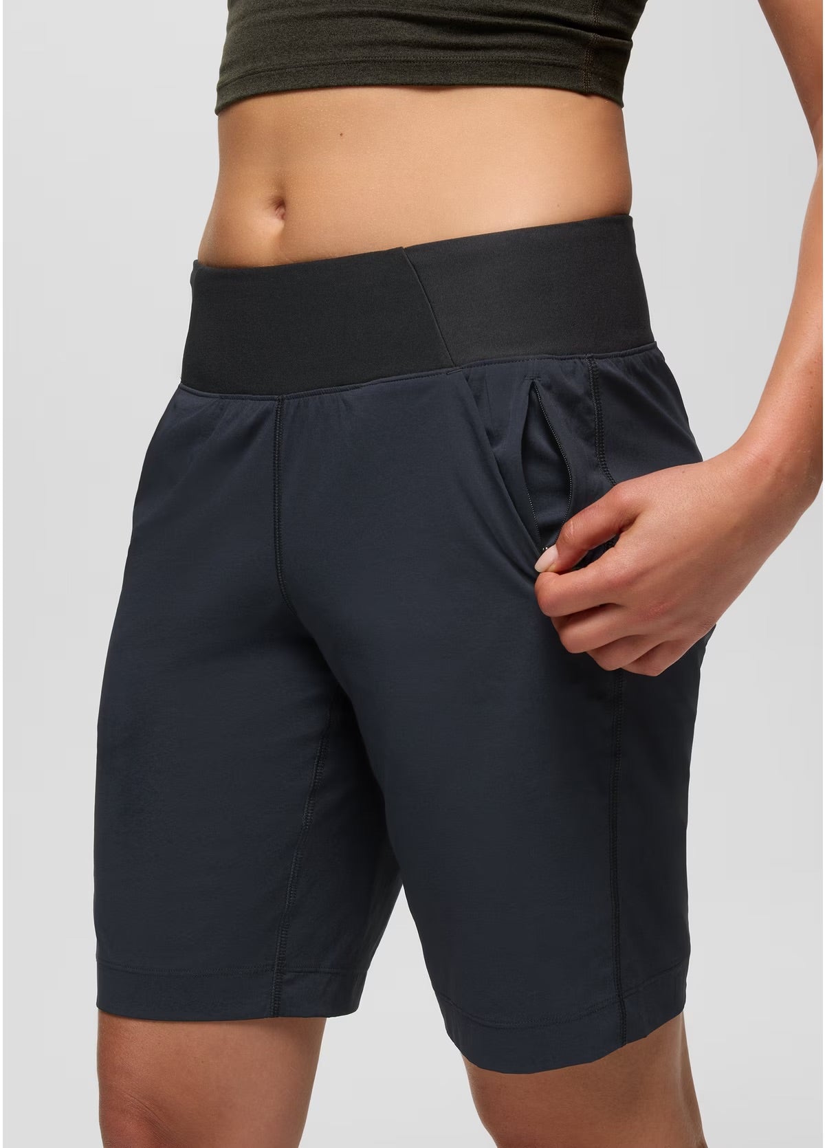 Person wearing black athletic shorts on a light gray background