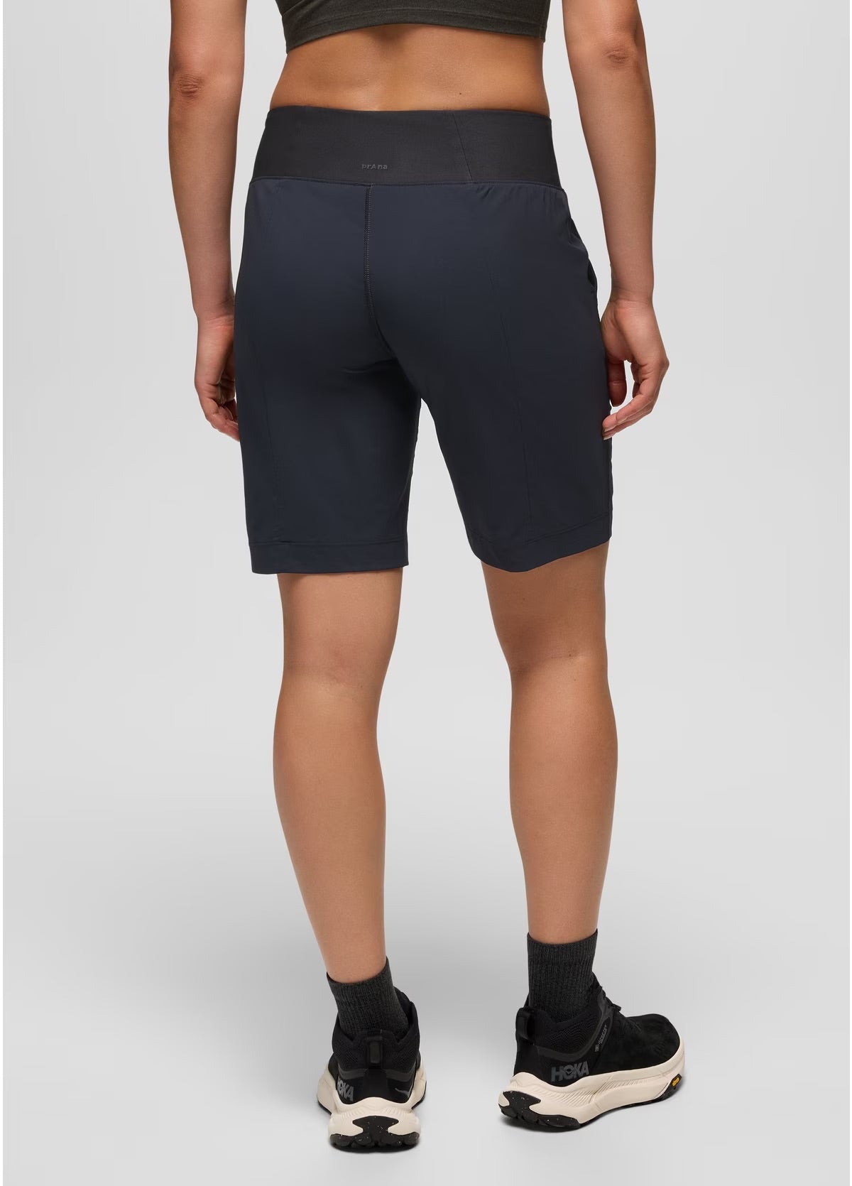 Person wearing black athletic shorts on a plain background