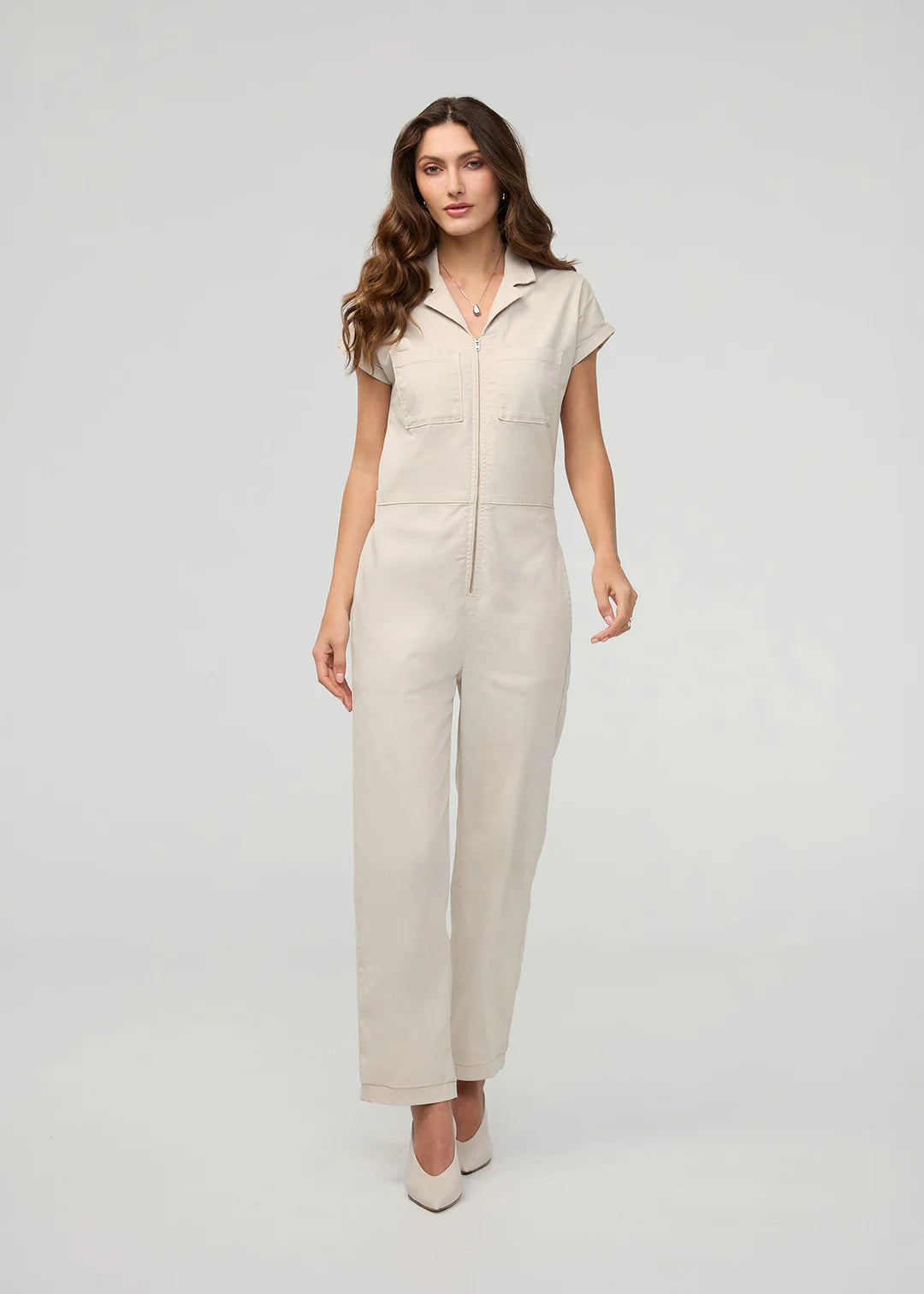 Woman wearing a beige jumpsuit on a white background