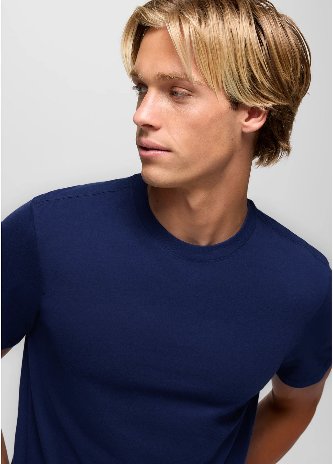 Man wearing a navy blue t-shirt against a plain background