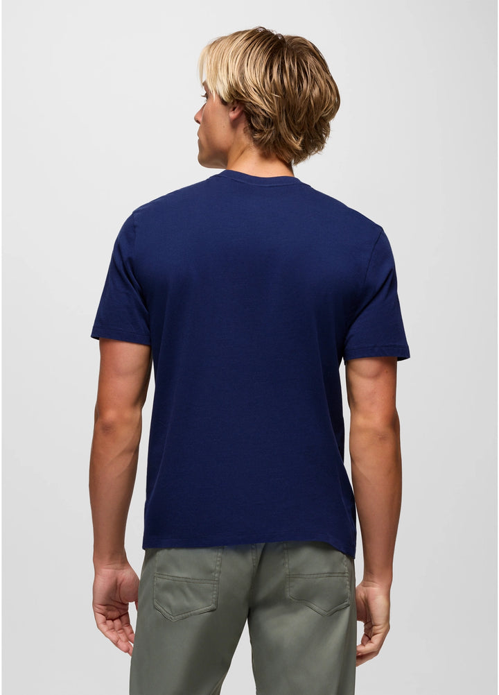 Man wearing a navy blue t-shirt and gray pants on a white background