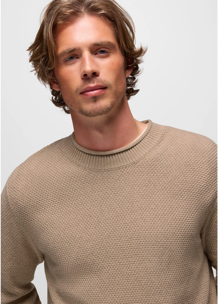 Man wearing a beige sweater against a plain background