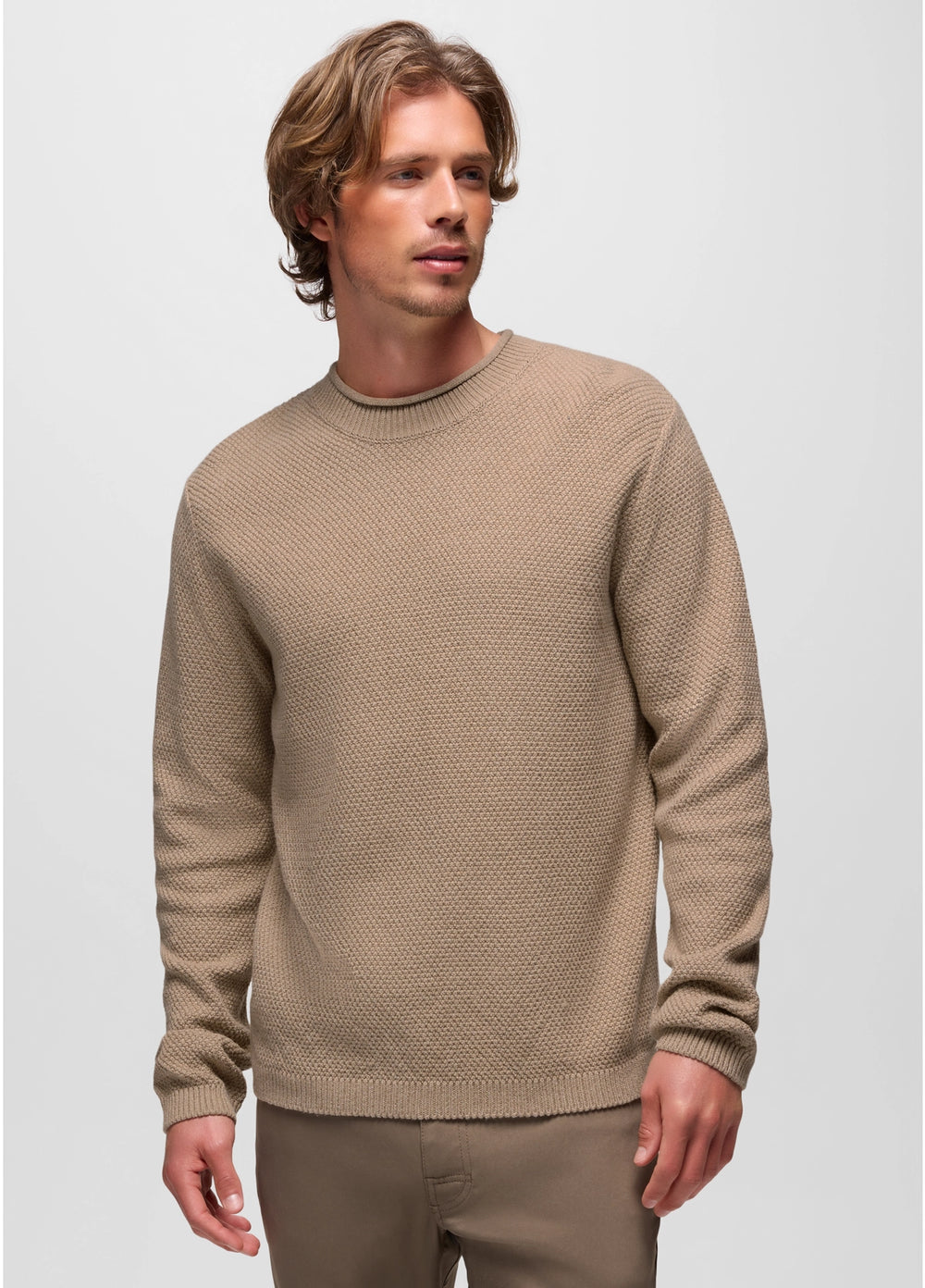 Man wearing a beige sweater against a plain background