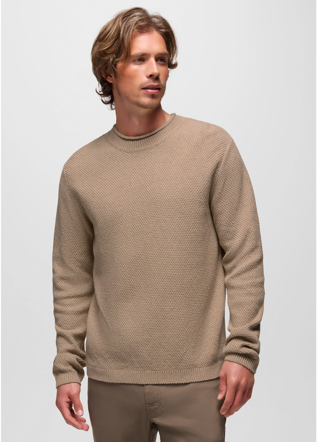 Man wearing a beige sweater against a plain background