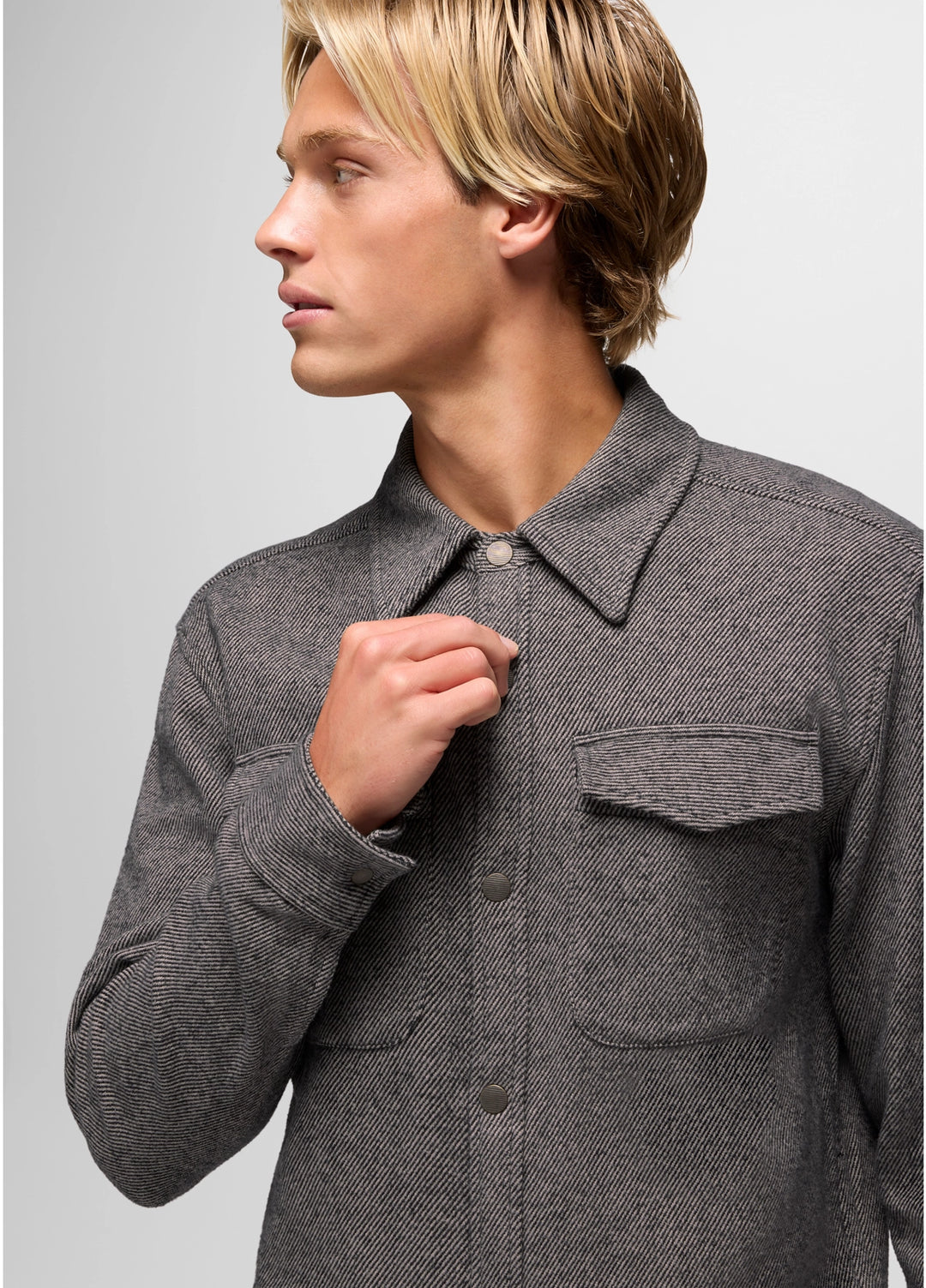 Person wearing a gray textured shirt against a light gray background