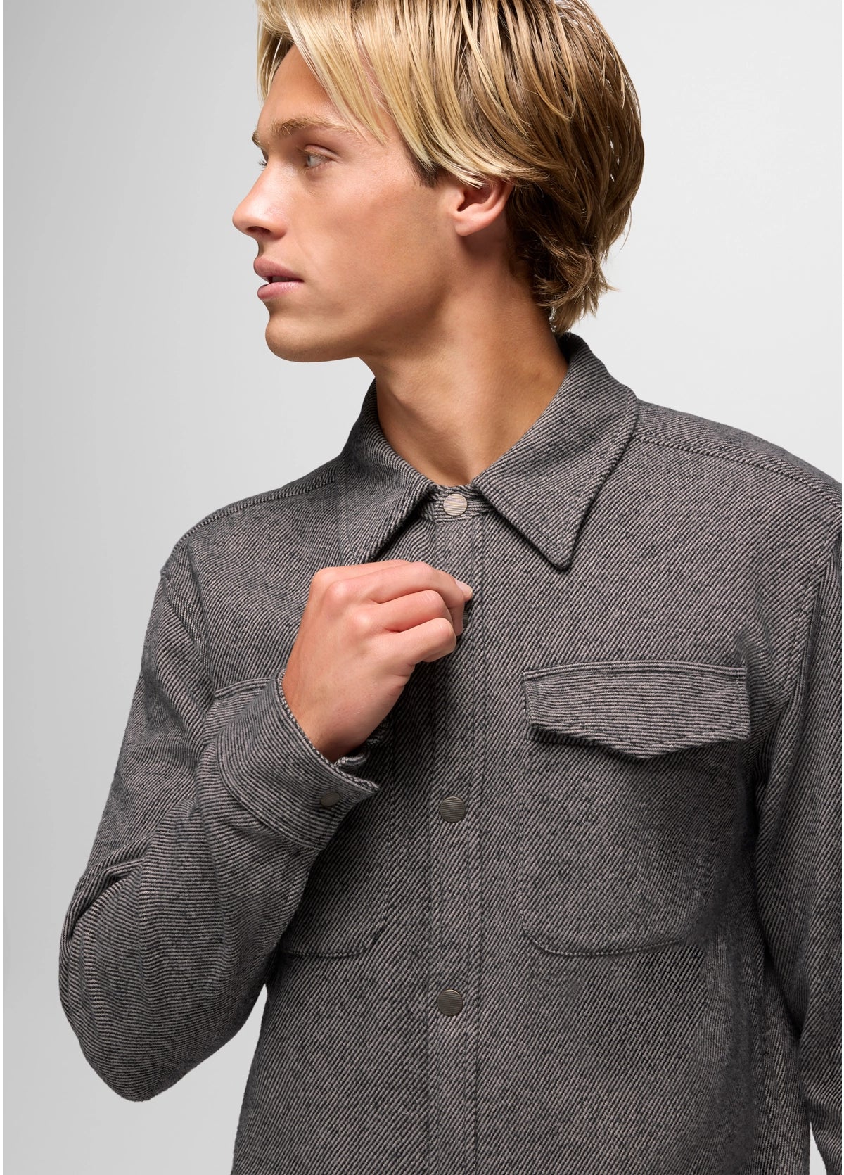 Person wearing a gray textured shirt against a light gray background