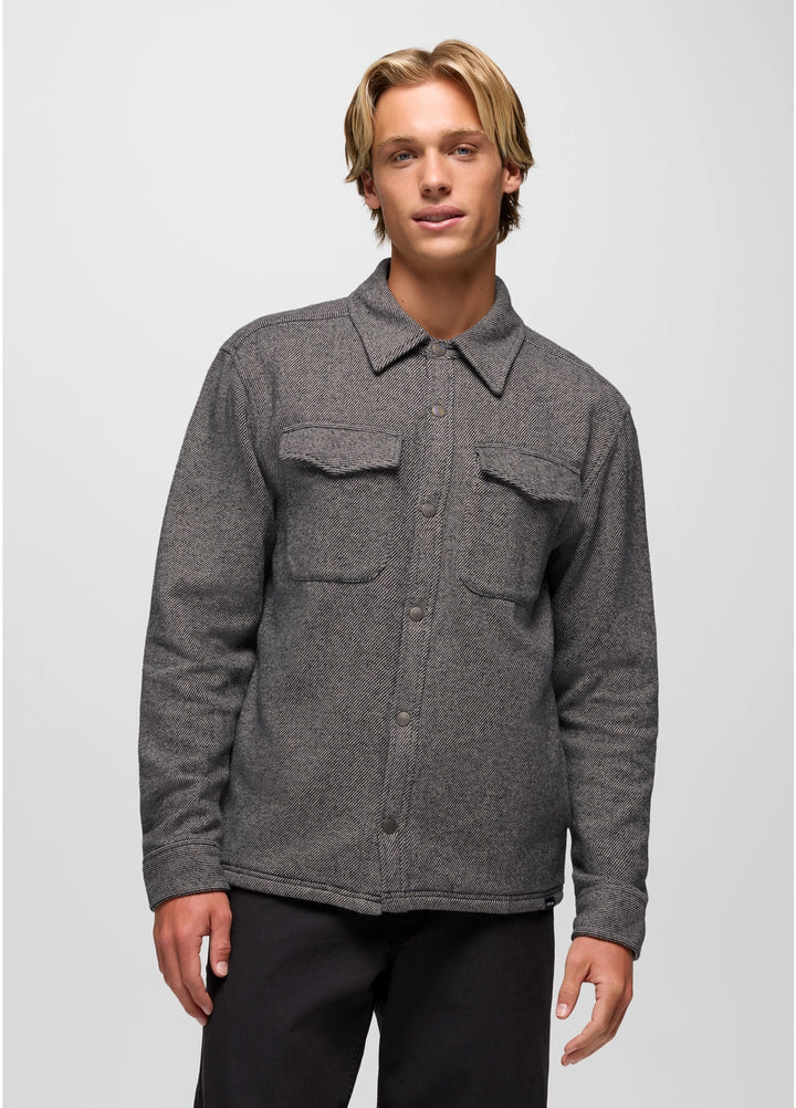 Man wearing a gray flannel shirt over a black shirt on a white background