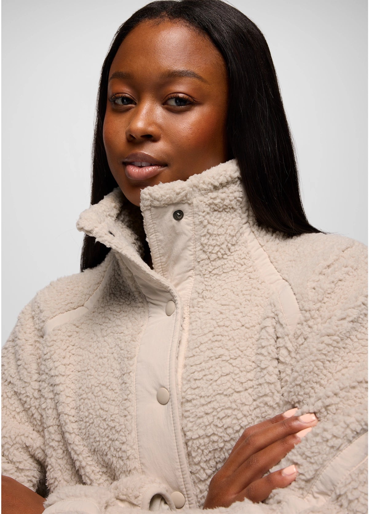Woman wearing a beige prAna Encinitas Fleece Jacket against a plain background