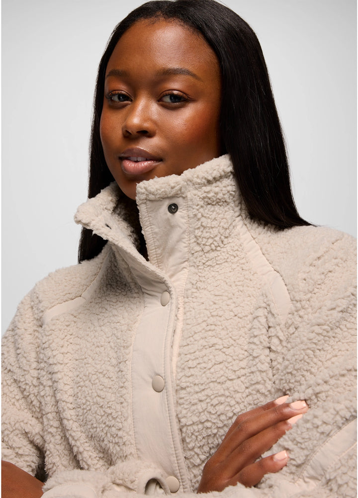 Woman wearing a beige prAna Encinitas Fleece Jacket against a plain background