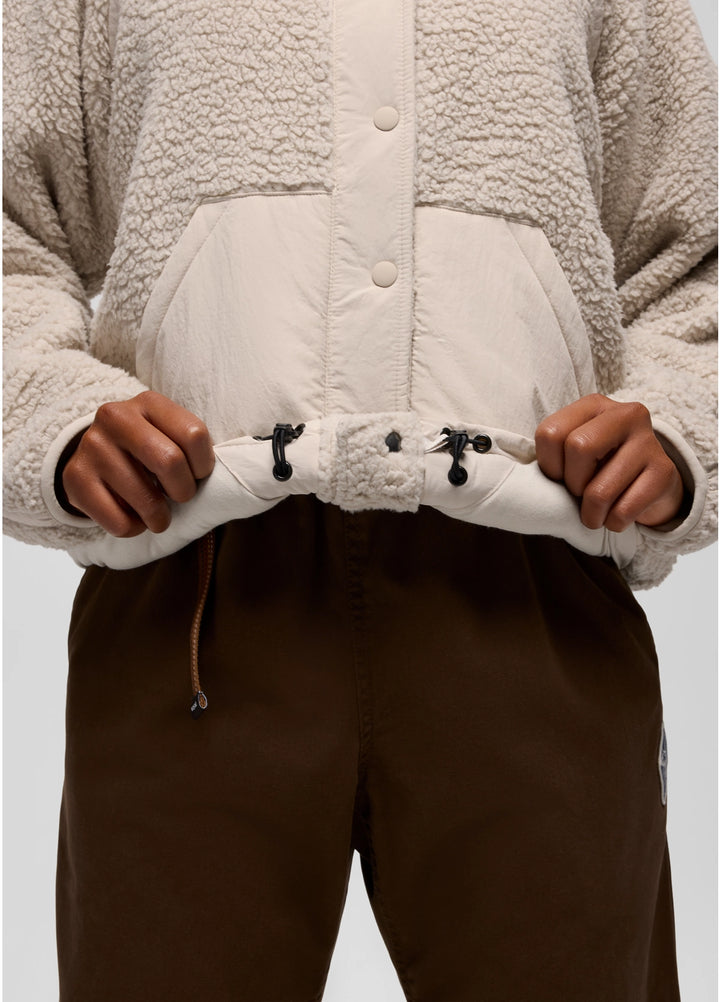 Close-up of a person wearing a beige prAna Encinitas Fleece Jacket with a white quilted panel.