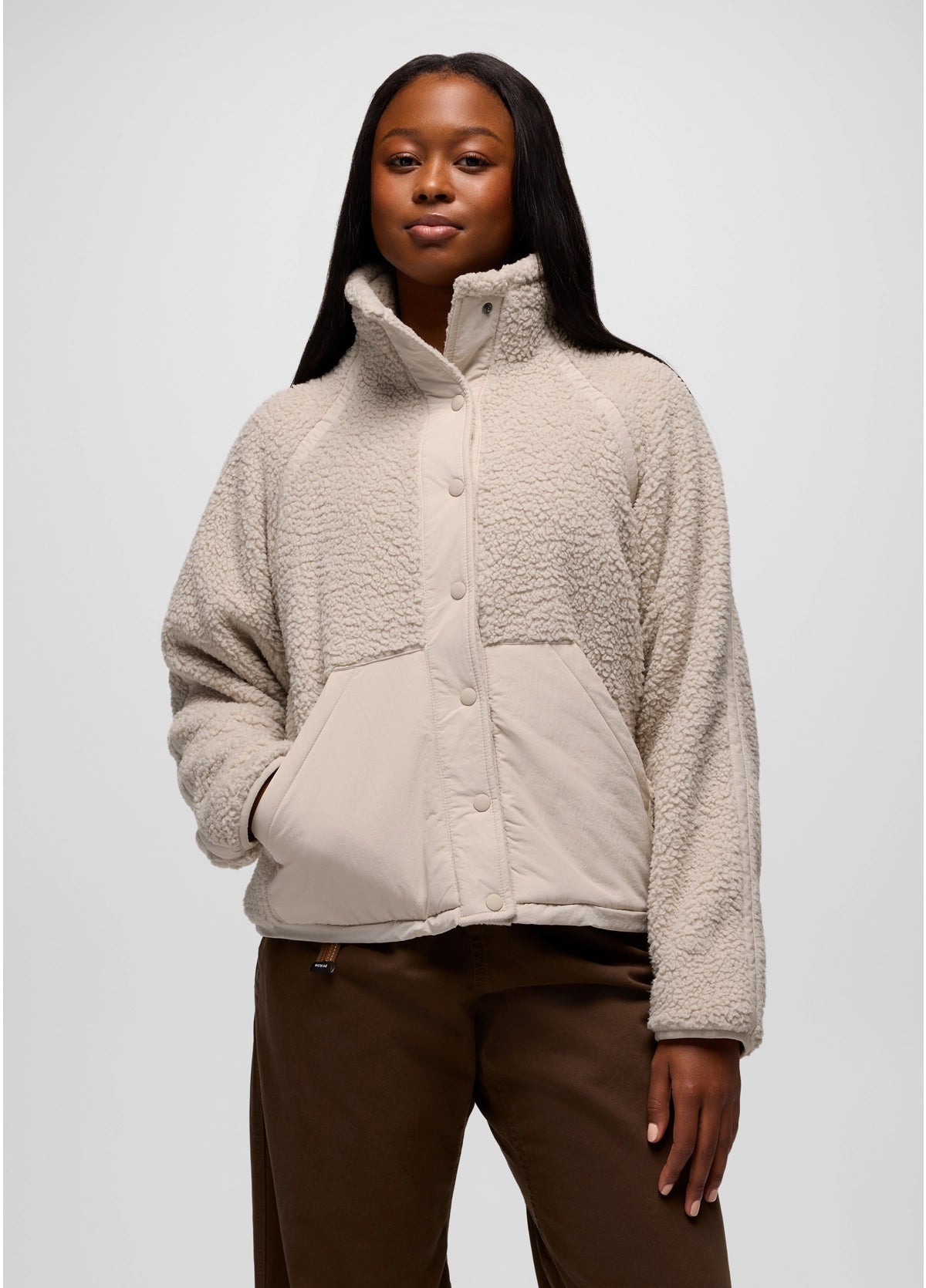 Woman wearing a beige prAna Encinitas Fleece Jacket against a white background