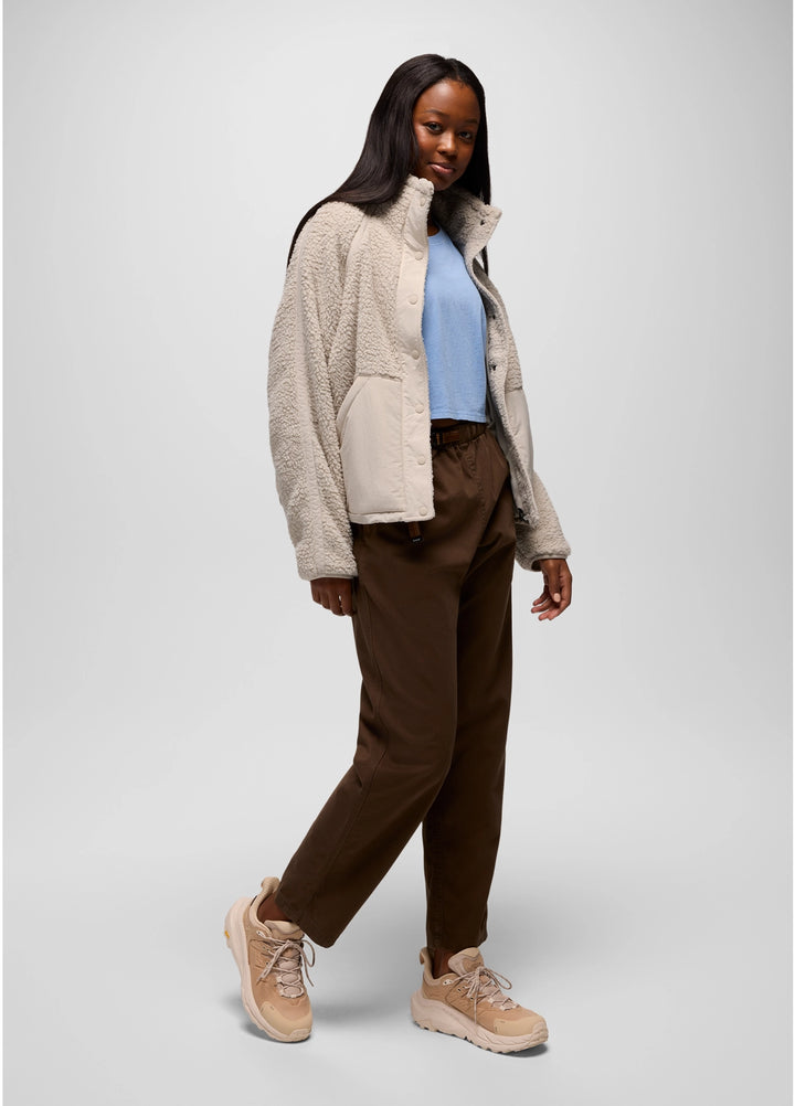 Woman wearing a beige prAna Encinitas Fleece Jacket, brown pants, and tan shoes on a white background