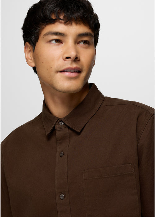 Man wearing a brown shirt against a plain background