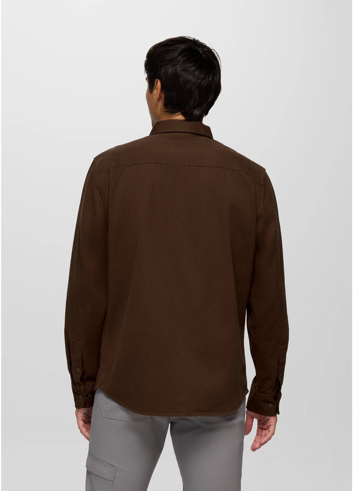 Man wearing a brown shirt and gray pants on a white background