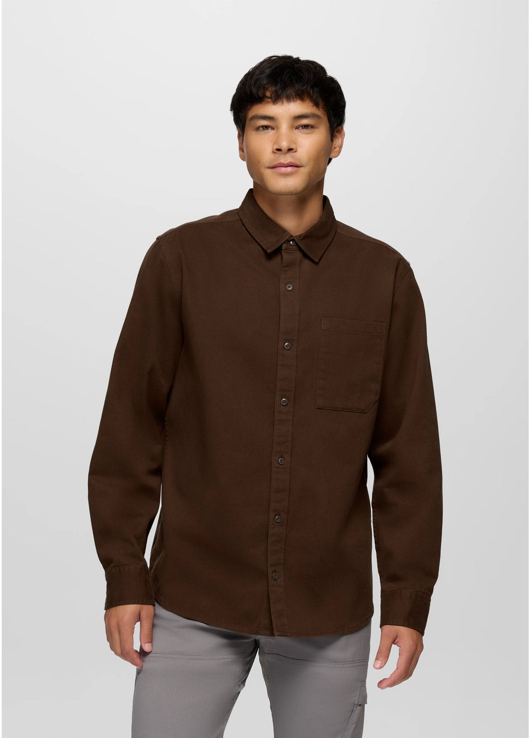 Man wearing a brown button-up shirt against a white background