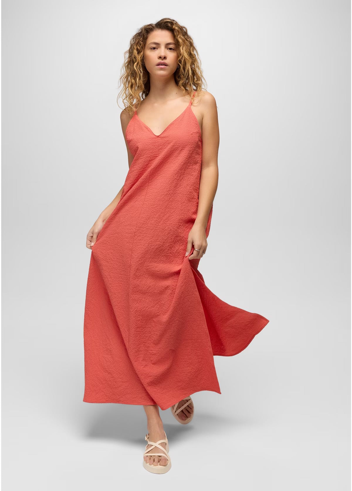 Woman wearing a coral pink dress on a white background