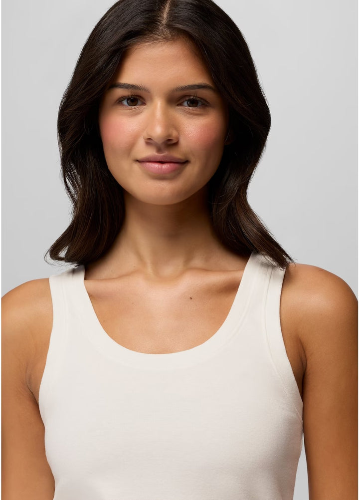 Woman wearing a white tank top against a plain background
