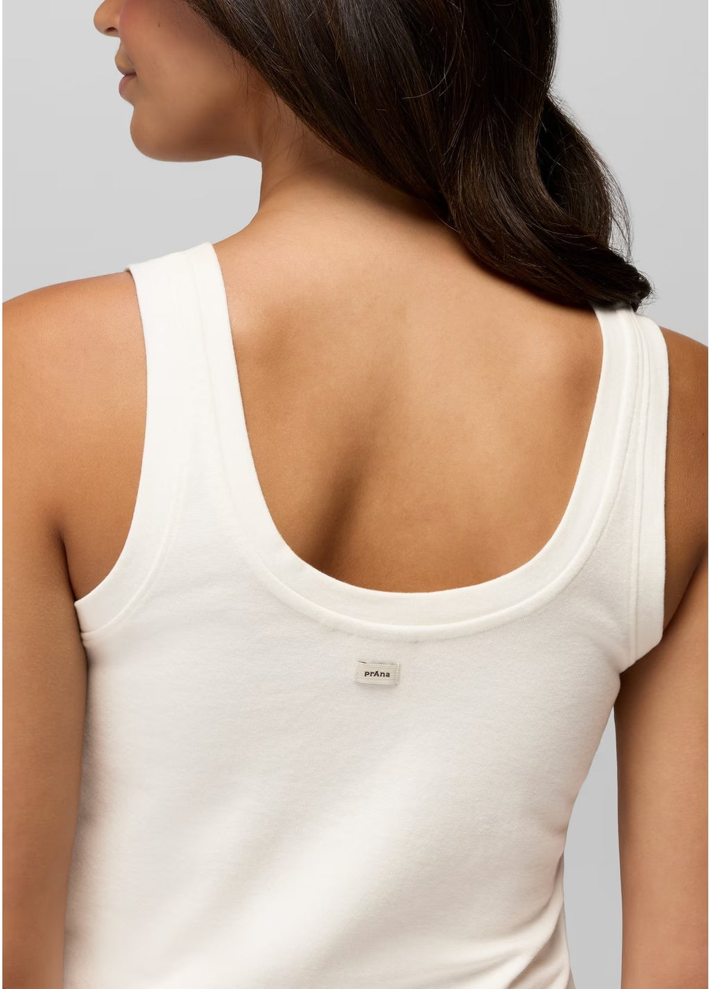 White tank top worn by a person on a plain background